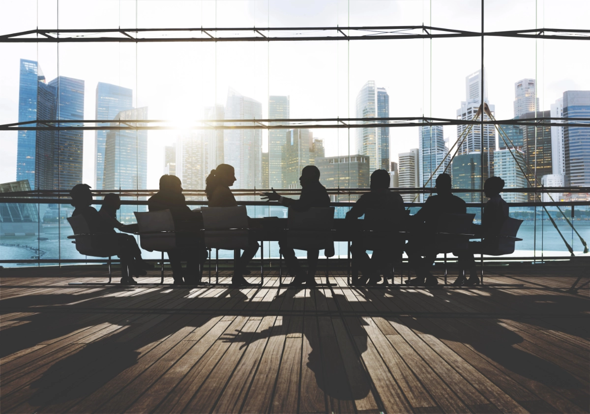 Menschen an einem Konferenztisch in einem großen Büro